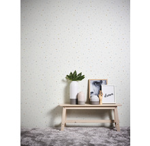 Dekorative Tapete mit Punktmuster in einem Raum mit einem kleinen Tisch, auf dem Vasen und Bilderrahmen stehen.