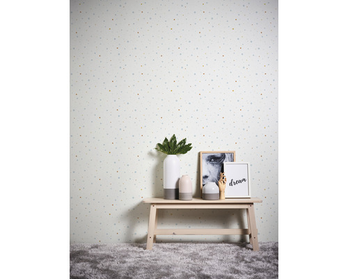 Dekorative Tapete mit Punktmuster in einem Raum mit einem kleinen Tisch, auf dem Vasen und Bilderrahmen stehen.