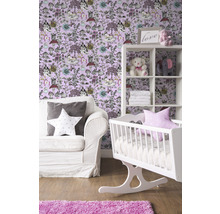 Chambre d''enfant avec berceau blanc, étagère et canapé devant un papier peint avec des motifs d''animaux