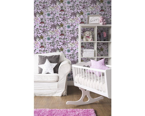 Chambre d''enfant avec berceau blanc, étagère et canapé devant un papier peint avec des motifs d''animaux