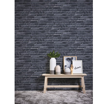 Dekorative Steinoptik Tapete über einem Tisch mit Vasen und Bildern.