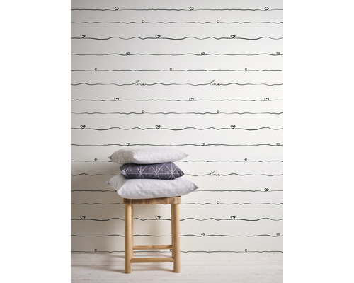 Papier peint à motif de lignes de cœur et coussins sur un tabouret