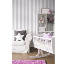 Chambre de bébé avec berceau, étagère, fauteuil et papier peint rayé