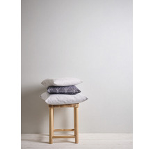 Pile de trois coussins sur un tabouret en bois