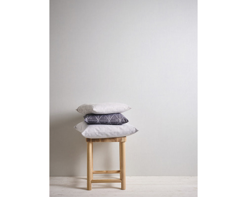 Pile de trois coussins sur un tabouret en bois