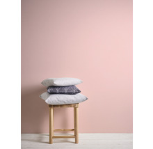 Coussins décoratifs sur un tabouret devant un mur