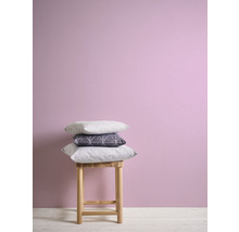 Coussins décoratifs sur un tabouret devant un mur