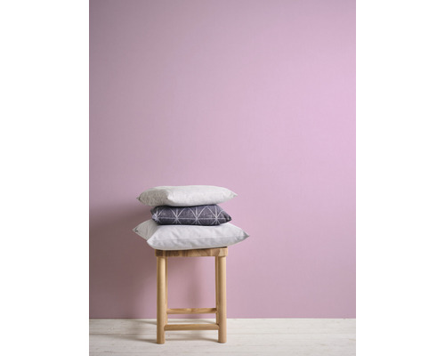 Coussins décoratifs sur un tabouret devant un mur