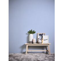 Dekorative Szene mit Bank, Vasen und Bildern vor einer Wand