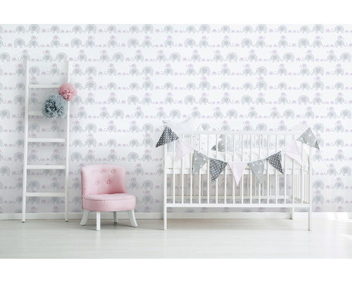Chambre d''enfant avec papier peint motif éléphant, échelle, fauteuil et lit de bébé.