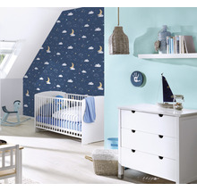 Chambre de bébé avec lit à barreaux, commode et papier peint bleu à motifs