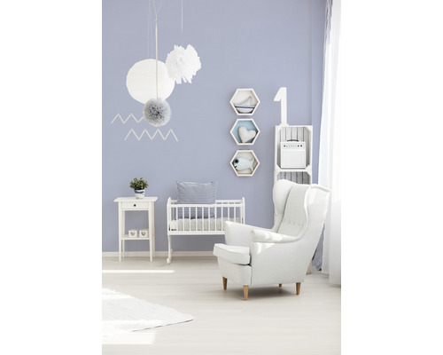 Chambre avec lit de bébé, fauteuil, table d''appoint et décorations