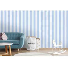 Chambre d''enfant avec papier peint rayé, canapé, table, jouets et sacs de rangement