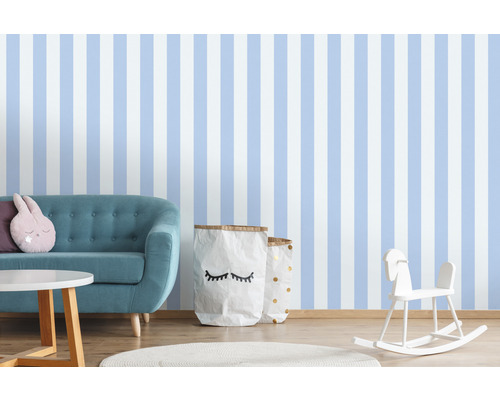 Chambre d''enfant avec papier peint rayé, canapé, table, jouets et sacs de rangement