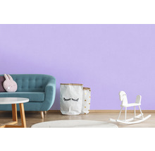 Chambre d''enfant avec canapé, table, jouets et décoration devant un mur