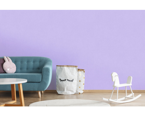 Chambre d''enfant avec canapé, table, jouets et décoration devant un mur