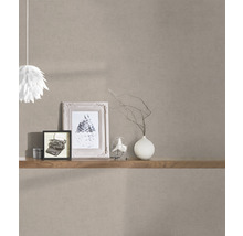 Dekoratives Zimmer mit brauner Vliestapete, Regal, Bildern und Lampe