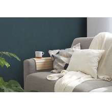 Nahaufnahme eines Sofas mit Kissen, Decke, Armlehnenauflage und Tasse.