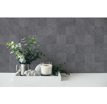 Dekoratives Arrangement mit einer Kerze, einer Pflanze und einer grauen Tapete mit Leinenstruktur