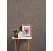 Tapete mit Textilmuster auf dem Hintergrund und Dekoration auf dem Tisch.