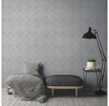 Salon avec papier peint géométrique gris, tabouret et lampadaire