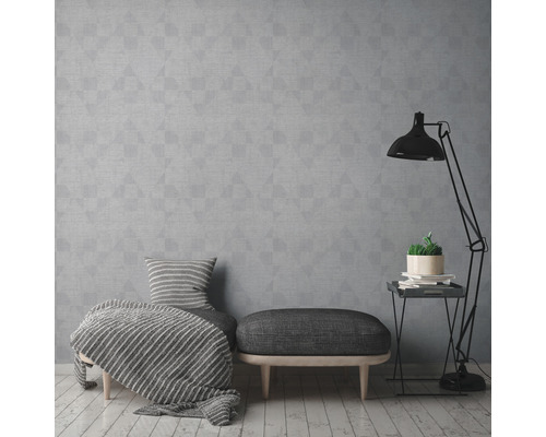 Salon avec papier peint géométrique gris, tabouret et lampadaire