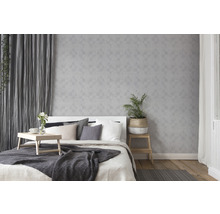 Chambre claire avec lit, table de chevet et papier peint géométrique