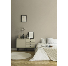 Schlafzimmer mit Bett, Kommode, rundem Teppich und Dekoration