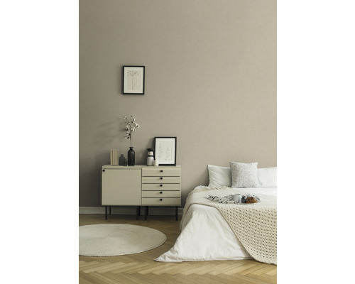 Schlafzimmer mit Bett, Kommode, rundem Teppich und Dekoration