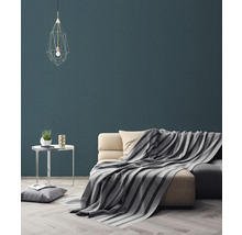 Wohnzimmer mit Sofa, Decke, Tisch und Pendelleuchte für eine gemütliche Atmosphäre