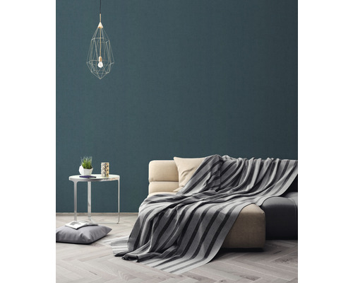 Wohnzimmer mit Sofa, Decke, Tisch und Pendelleuchte für eine gemütliche Atmosphäre