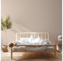 Helles Schlafzimmer mit Holzbett, Bettwäsche und Dekorationen