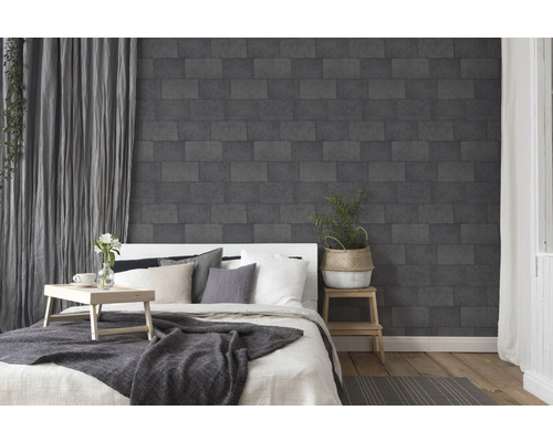 Schlafzimmer mit Bett und dunkler Steinoptik Tapete an der Wand