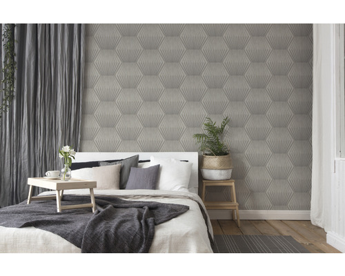 Chambre avec lit devant un mur avec du papier peint à motif géométrique