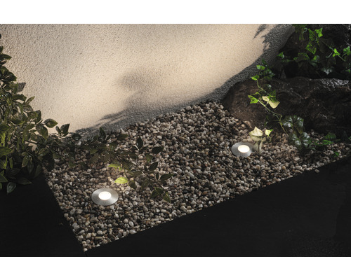 Gartenszene mit Bodeneinbaustrahlern, Kies und Bepflanzung