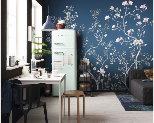 Wohnraum mit Kühlschrank, Esstisch und Wandtapete mit floralem Muster