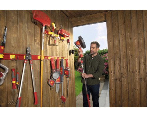 Outils de jardin et rail à outils pour le rangement dans une cabane de jardin avec un homme