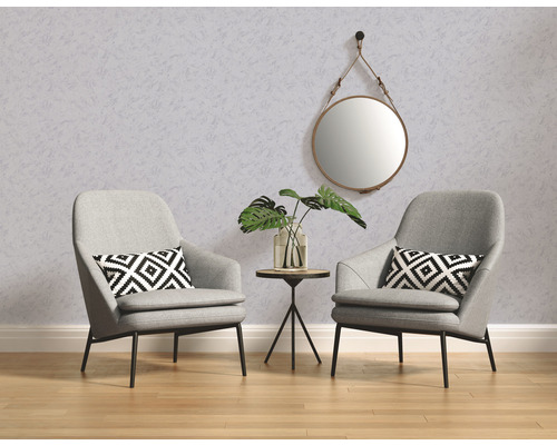 Zwei Sessel mit Kissen, Tisch mit Pflanze und Spiegel an der Wand.