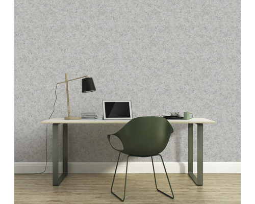 Un bureau avec un bureau devant un papier peint gris.