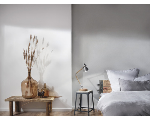 Dekoratives Schlafzimmer mit Bett, Beistelltisch, Lampe und Dekorationen wie Vasen und Trockenblumen