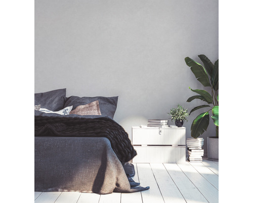 Helles Schlafzimmer mit Bett, Nachttisch und Zimmerpflanzen