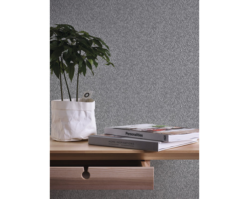 Gros plan d''un papier peint gris avec motif végétal recouvrant un mur de pièce.