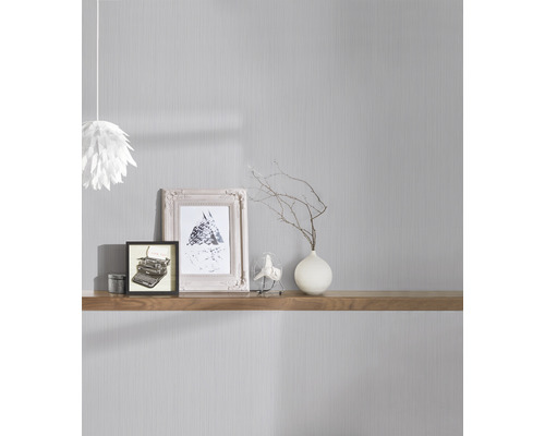 Espace de vie avec papier peint gris, étagère en bois, photos et éléments décoratifs