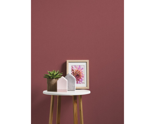 Nature morte décorative avec plante, décorations de maison et cadre photo sur une table devant un mur