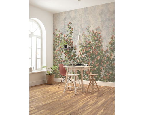 Esszimmer mit Esstisch, Stühlen und Wandtapete mit Rosenmotiv.