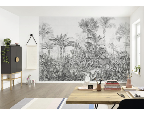 Wohnraum mit einer Fototapete mit Dschungelmotiv, die Palmen und Leoparden zeigt.