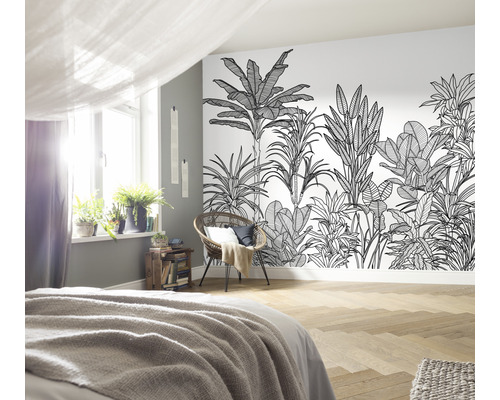 Schlafzimmer mit Dschungel-Tapete, Bett, Stuhl und Zimmerpflanzen