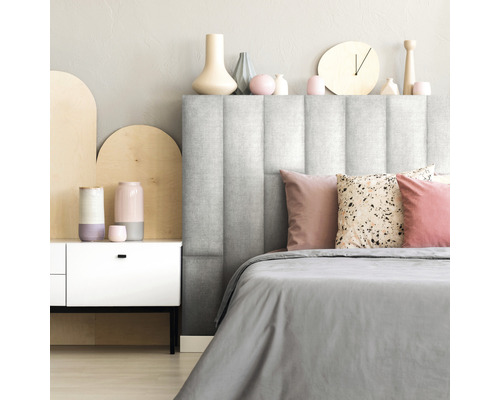 Schlafzimmer mit gepolstertem Kopfteil, Nachttisch und dekorativen Accessoires