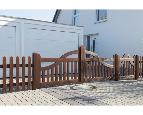 Clôture en bois avec des éléments décoratifs devant une maison