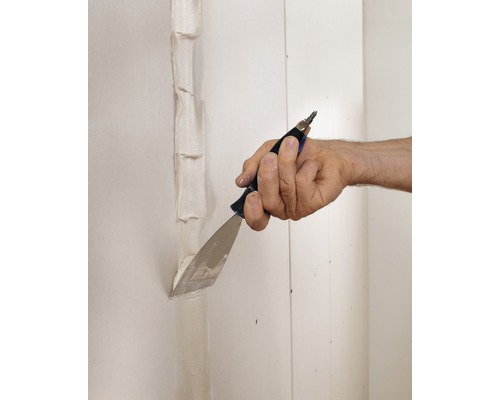 Une main enduit les joints d''une plaque de plâtre avec un couteau à enduire